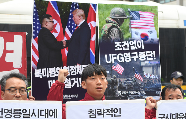 -Des militants sud-coréens tiennent des pancartes montrant des images du sommet Trump-Kim et d'un exercice militaire conjoint entre la Corée du Sud et les États-Unis lors d'un rassemblement. Exercice, près de l'ambassade américaine à Séoul le 15 juin 2018. L'armée américaine a reporté à une date ultérieure indéterminée d'importants exercices communs avec la Corée du Sud. Photo de Jung Yeon-je / AFP / Getty Images.