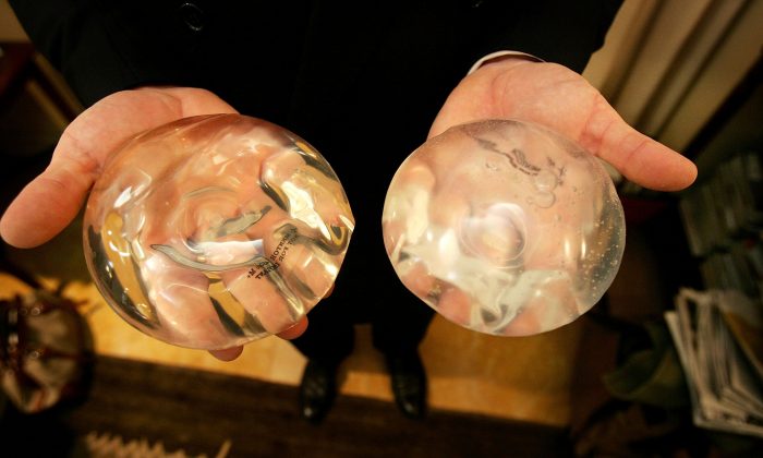 Le Dr Brad Jacobs tient un gel d'implant en silicone (L) et un gel d'implant salin (R) à son bureau à New York, le 21 novembre 2006. (Spencer Platt/Getty Images)
