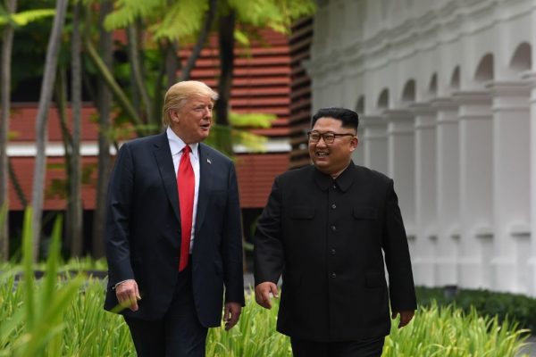 Le leader nord-coréen Kim Jong Un (à d.) accompagne le président américain Donald Trump lors d'une pause dans les pourparlers au cours du sommet historique États-Unis–Corée du Nord tenu à Singapour, le 12 juin 2018. (Saul Loeb/AFP/Getty Images)