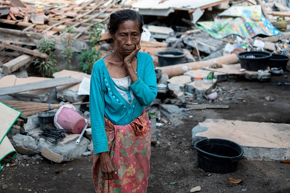 Une femme regarde devant sa maison qui s'est effondrée dans le village de Labu Pandan sur l'île de Lombok, en Indonésie, le 22 août 2018, après une série de tremblements de terre. (Photo : FRED DUFOUR/AFP/Getty Images)