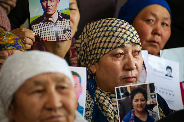 -Des requérants de parents disparus ou détenus au Xinjiang présentent des photos de leurs proches lors d'une conférence de presse organisée dans les locaux du groupe de défense des droits Ata Jurt à Almaty, au Kazakhstan, le 21 janvier 2019. Photo de Ruslan PRYANIKOV / AFP / Getty Images.