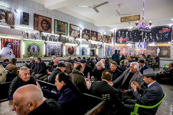 -Des hommes irakiens se rassemblent et se rencontrent au café Umm Kulthum, rue Rasheed, la plus vieille rue de la capitale Bagdad, le 20 janvier 2019. Derrière les vitrines délabrées et l'effondrement des colonnades de la rue Rasheed, se cachent les trésors de la grande expansion culturelle de la capitale irakienne. Photo de SABAH ARAR / AFP / Getty Images.