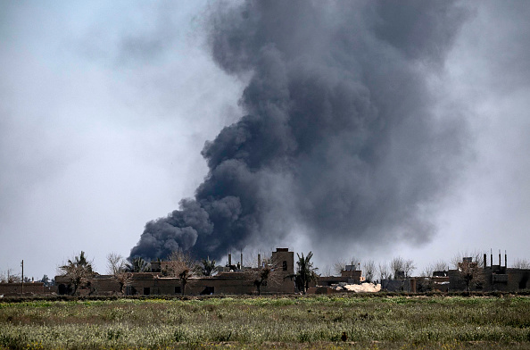 -Une fumée vue le 11 mars d'une bataille entre les Forces démocratiques syriennes soutenues par les États-Unis et les djihadistes du groupe État islamique dans le village de Baghouz, près de la frontière entre la Syrie et l'Irak, dans la province de Deir Ezzor. Le 11 mars 2019. Photo par Delil souleiman / AFP / Getty Images.