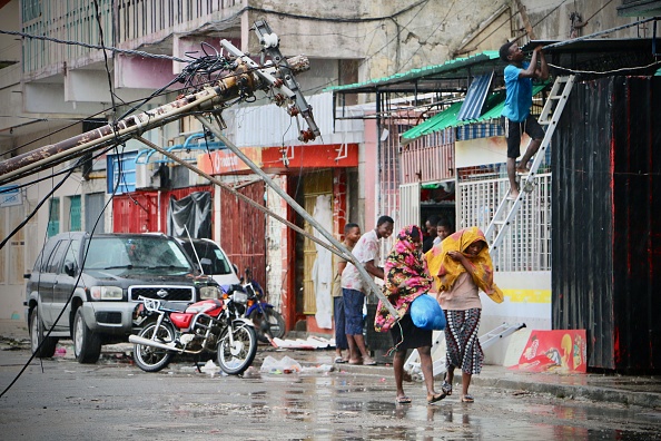 -On a vu des résidents se protéger contre la pluie après le passage du cyclone Idai à Beira, au Mozambique, le 17 mars 2019. Plus de 120 personnes sont mortes et de nombreuses autres sont portées disparues au Mozambique et au Zimbabwe, pays voisin. Photo par ADRIEN BARBIER / AFP / Getty Images.