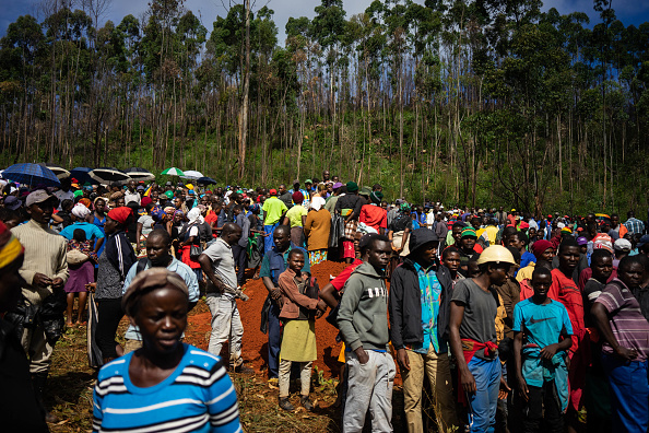 -Des personnes assistent à l'inhumation des victimes dans la ville de Ngangu dans l'est du Zimbabwe, le 18 mars 2019, après le passage du cyclone Idai dans la région. Un cyclone qui a dévasté le Mozambique et le Zimbabwe a fait au moins 162 morts et de nombreux disparus. Photo de ZINYANGE AUNTONY / AFP / Getty Images.