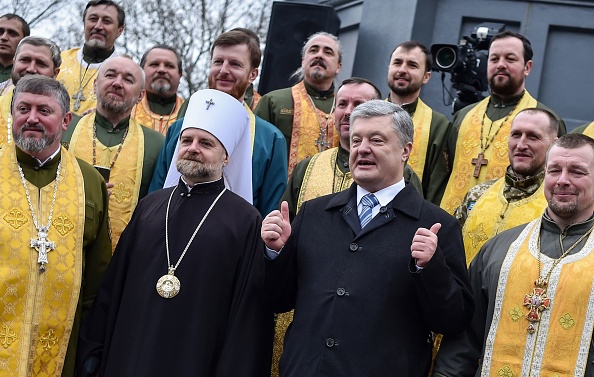 -Le président ukrainien Petro Poroshenko pose pour une photo avec des prêtres après une prière en plein air organisée pour l'élection juste par les prêtres de l'Église orthodoxe d'Ukraine et les autres confessions à Kiev, le 30 mars 2019, à la veille de la fête ukrainienne. Photo de Sergei GAPON / AFP / Getty Images.