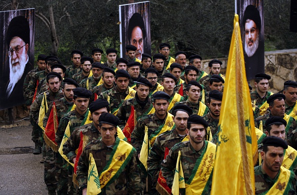 -Des combattants libanais du Hezbollah défilent près des portraits du guide suprême iranien, l'ayatollah Ali Khamenei (à gauche), fondateur de la République islamique d'Iran, le défunt Ayatollah Ruhollah Khomeini et du chef du Hezbollah, Hassan Nasrallah, lors d'une parade organisée dans la ville libanaise du sud du Liban. Photo MAHMOUD ZAYYAT / AFP / Getty Images.