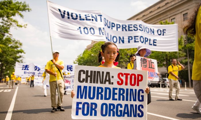 Une jeune pratiquante de Falun Gong tient un panneau demandant à la Chine de cesser de tuer des prisonniers de conscience pour leurs organes, lors d’une manifestation à Washington, le 20 juillet 2017. (Benjamin Chasteen/Epoch Times)