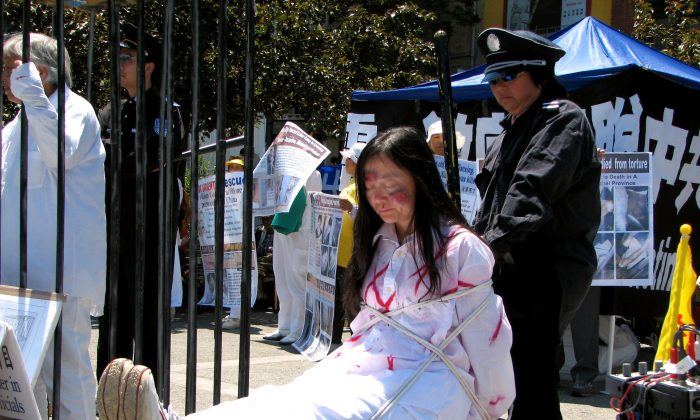 Une reconstitution d'une pratiquante de Falun Gong en train d'être torturée. (Minghui.org)