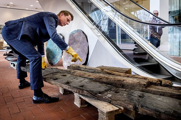 -Un homme montre des plaques de cuivre provenant d'une épave de navire datant de 1536 découverte lors du stockage des conteneurs perdus du navire MSC Zoe plus tôt cette année, à Amersfoort, le 3 avril 2019. Photo de Koen van Weel / ANP / AFP / Getty Images.