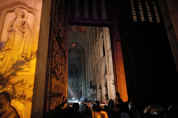 -La vue générale de l'entrée montre la fumée qui monte devant l'autel en croix de la cathédrale Notre-Dame de Paris le 15 avril 2019, après qu'un incendie ait ravagé l'immeuble. Photo de PHILIPPE WOJAZER / POOL / AFP / Getty Images.