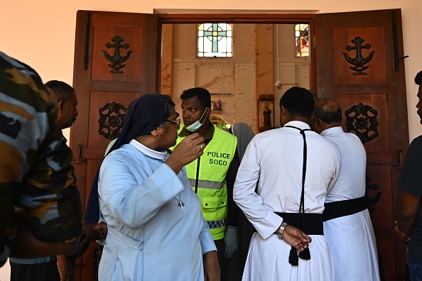 -Une religieuse surveille alors que des membres des forces de sécurité inspectent l'église Saint-Sébastien de Negombo le 22 avril 2019. L'une des pires violences survenues sur l'île depuis la guerre civile dévastatrice qui a pris fin il y a dix ans. Photo de Jewel SAMAD / AFP / Getty Images.