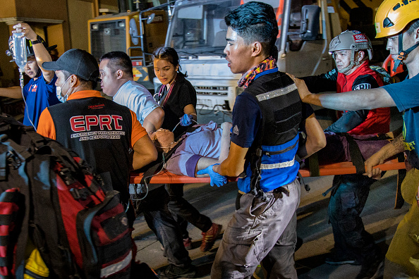 -Les sauveteurs emmènent une victime qui était coincée dans les débris d'un immeuble commercial de quatre étages, qui s'est effondré à la suite d'un séisme de magnitude 6,3, le 23 avril 2019 à Porac, dans la province de Pampanga, aux Philippines. Photo de Ezra Acayan / Getty Images.