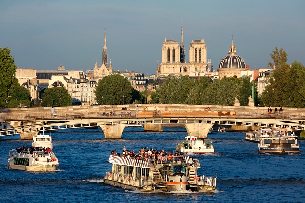 -Bateaux fluviaux touristiques naviguant sur la Seine, avec vue sur la cathédrale Notre-Dame. Paris, le 28 juin 2017. Photo de LUDOVIC MARIN / AFP / Getty Images.