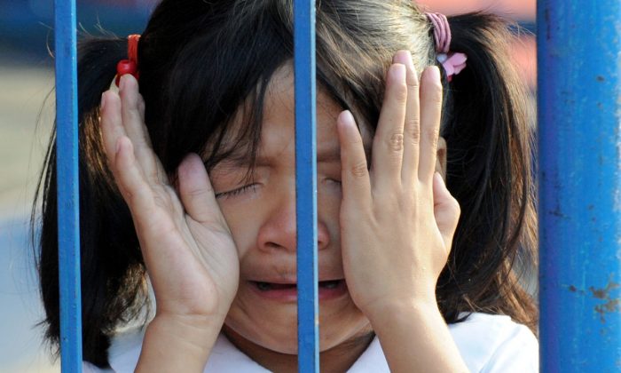 Une fille qui pleure derrière une grille. (JAY DIRECTO/AFP/Getty Images)
