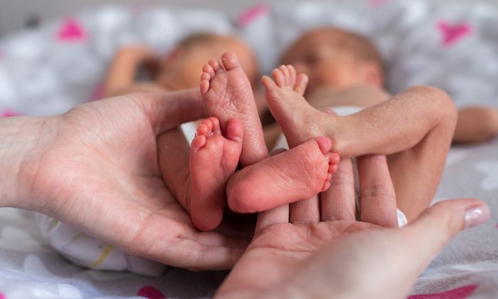Photo illustrant les pieds de deux nouveau-nés.