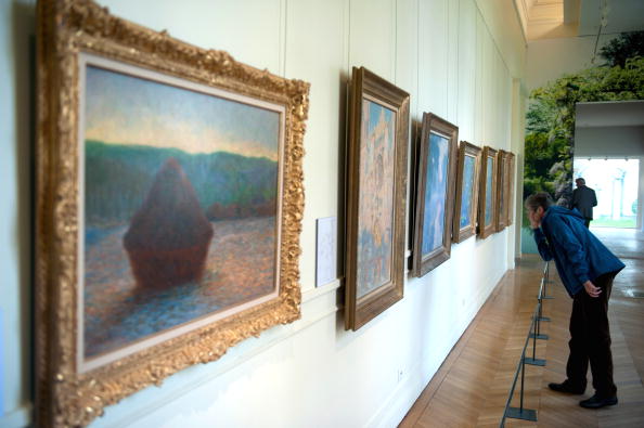-Un visiteur découvre les peintures de l'artiste français Claude Monet (au premier plan "La meule") au musée Marmottant le 7 octobre 2010 dans le cadre d'une exposition consacrée au peintre impressionniste à Paris. Photo ETIENNE LAURENT / AFP / Getty Images.