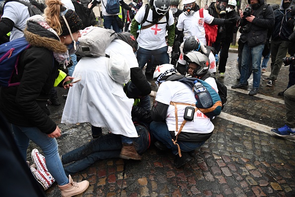 Des"street medics" viennent en aide à un homme lors des affrontements qui ont éclaté le 19 janvier 2019 à Paris.  (Photo : ERIC FEFERBERG/AFP/Getty Images)