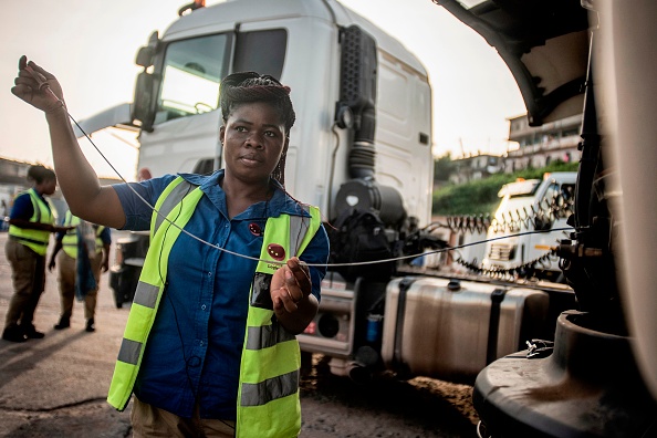 -L'une des 21 conductrices de poids de Ladybird Logistics vérifie le niveau d'huile de son camion avant le début de la journée de travail à Takoradi, dans l'ouest du Ghana, le 3 avril 2019. L'équipe féminine de Ladybird conduit de lourds camions de 47 000 litres à travers le pays d'Afrique de l'Ouest, approvisionnant en carburant les célèbres mines d'or du Ghana. Photo de CRISTINA ALDEHUELA / AFP / Getty Images.