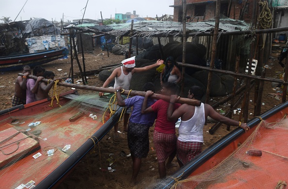 -Le 2 mai 2019, des pêcheurs indiens tirent un bateau vers un terrain plus élevé sur une plage de Puri, dans l'état indien d'Odisha, dans l'est de l'Inde, alors que le cyclone Fani s'approche de la côte indienne. Près de 800 000 personnes dans l'est de l'Inde ont été évacuées de la trajectoire prévue d'un cyclone majeur. Photo de Dibyangshu SARKAR / AFP / Getty Images.