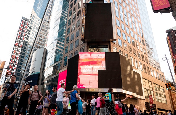 -Les touristes passent devant un panneau d'affichage électronique endommagé à Times Square le 18 mai 2019 à New York, après avoir brièvement pris feu. L’incendie a été rapidement éteint, aucun blessé n’a été signalé ni aucun dommage au bâtiment, ont indiqué des responsables. Photo de Johannes EISELE / AFP / Getty Images.