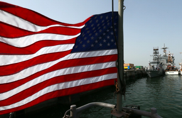 -Illustration-Un drapeau américain flotte près des bateaux de la marine américaine amarrés au port de Bahreïn Salman, avant le début du plus grand exercice de manœuvres de lutte contre les mines dans le golfe Persique. Photo MARWAN NAAMANI / AFP / Getty Images.
