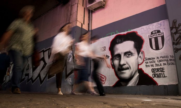 Les gens passent devant une peinture murale avec le portrait de l’écrivain britannique George Orwell et la phrase « La liberté est le droit de dire aux gens ce qu'ils ne veulent pas entendre », à Belgrade, le 8 mai 2018. (OLIVER BUNIC/AFP/Getty Images)