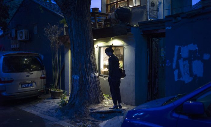 Une femme devant une maison en Chine. (FRED DUFOUR/AFP/Getty Images)