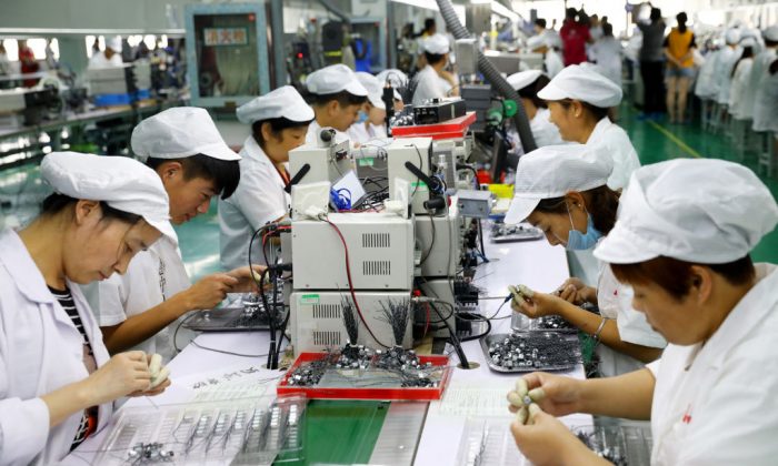 Des employés travaillent sur une ligne de production de micromoteurs d’une usine à Huaibei, le 23 juin 2018. (-/AFP/Getty Images)