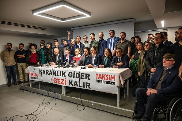 -Des membres de la plate-forme de solidarité Taksim posent devant une banderole indiquant "Les ténèbres iront, Gezi restera" le 11 mars 2019 lors d'une conférence de presse à Istanbul. Ils ont rejeté les inculpations "irrationnelles" et "illégales" visant l'éminent homme d'affaires turc Osman Kavala et 15 autres. Photo par Ozan KOSE / AFP / Getty Images.