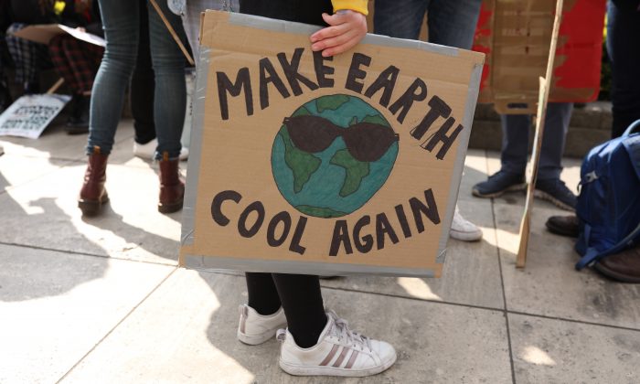 Un manifestant tient un panneau « Rafraîchissez à nouveau la Terre » lors de la marche étudiante YouthStrike4Climate organisée à Londres, le 12 avril 2019. (Dan Kitwood/Getty Images)