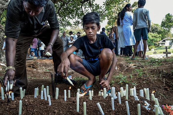 Un garçon allume une bougie lors des obsèques d'une victime des attentats de Pâques le 24 avril 2019 à Colombo, Sri Lanka. (Atul Loke/Getty Images)