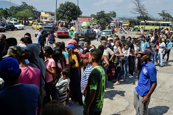 -Des gens font la queue pour recevoir de l'argent près du pont international Simon Bolivar à Cucuta, en Colombie, à la frontière avec le Venezuela, le 1er mai 2019. Photo de Luis ROBAYO / AFP / Getty Images.