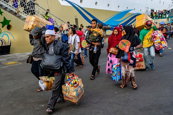 -Les passagers débarquent d'un navire dans un port de mer à Surabaya, dans la province de Java oriental en Indonésie, le 31 mai 2019, les gens se rendent dans leur ville d'origine avant l'Aïd al-Fitr, marquant la fin du mois de jeûne sacré du Ramadan. Photo de JUNI KRISWANTO / AFP / Getty Images.