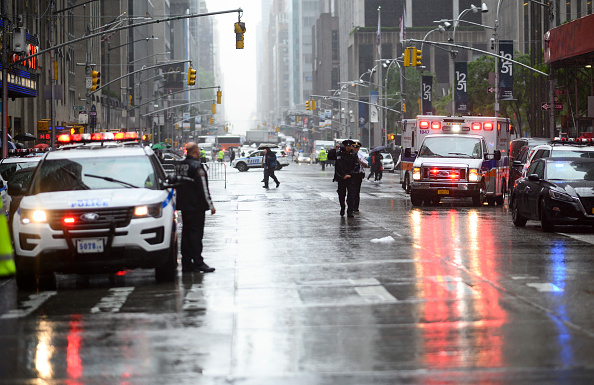 Des policiers se tiennent près des véhicules des services d'urgence après qu'un hélicoptère se soit écrasé au sommet d'un immeuble dans le centre-ville de Manhattan, à New York, le 10 juin 2019.  (Photo : JOHANNES EISELE/AFP/Getty Images)