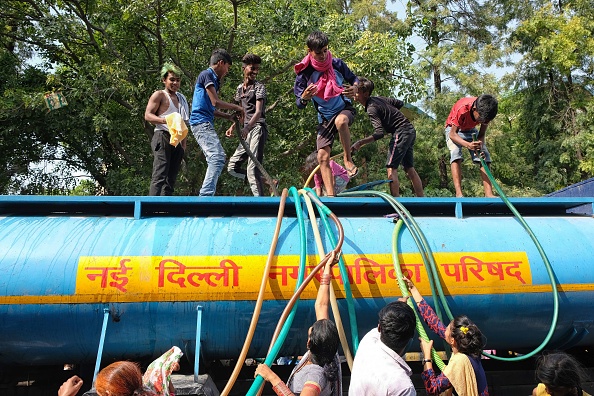 -Des résidents indiens utilisent des tuyaux pour collecter l'eau potable d'un camion-citerne pendant une chaude journée d'été dans un quartier à faible revenu du camp de Sanjay à New Delhi le 12 juin 2019. Photo de Noemi CASSANELLI / AFP / Getty Images.