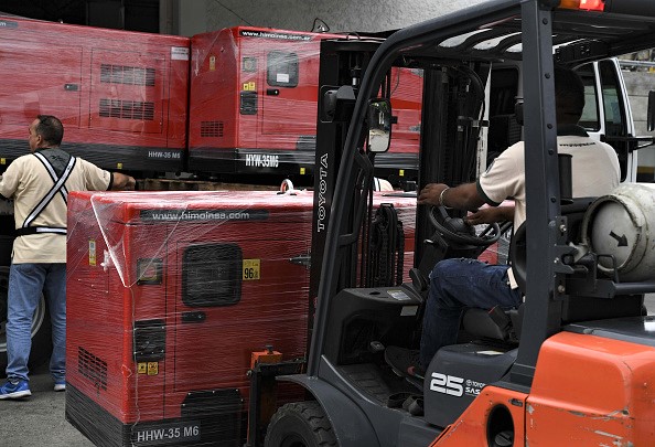 -Un travailleur décharge des groupes électrogènes reçus dans le cadre de l'aide humanitaire par l'intermédiaire de la Croix-Rouge vénézuélienne à Caracas (Venezuela) le 17 juin 2019. Photo de YURI CORTEZ / AFP / Getty Images.