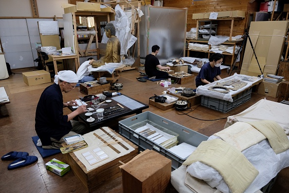 -Cette photo prise le 4 juin 2019 montre Takao Makino responsable du studio de conservation Kibi, en train de réparer des biens culturels à Saitama, près de Tokyo. Autrefois indispensable à la vie quotidienne des Japonais, le washi littéralement "papier japonais" était utilisé non seulement pour l'écriture et la peinture, mais également pour les portes coulissantes, les cloisons, les abat-jours et les parapluies. Photo par Kazuhiro NOGI / AFP / Getty Images.