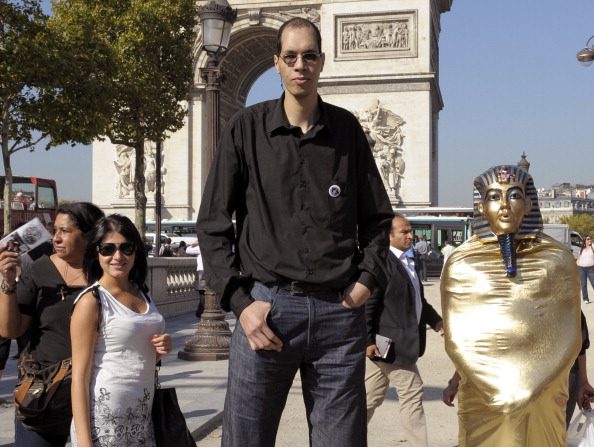 Le Marocain Brahim Takioullah (C), qui a les plus grands pieds au monde selon le livre Guinness des Records, pose près de l'Arc de Triomphe sur les Champs-Élysées le 29 septembre 2011 à Paris. (BERTRAND GUAY/AFP/Getty Images)