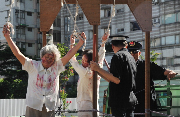 -Simulation d’une scène de torture lors d'une manifestation à Taipei le 20 juillet 2014 contre la persécution par la Chine. L'arrêt de la Cour d'appel de Nouvelle Zélande critique très sévèrement l'état du système judiciaire chinois. Photo Mandy Cheng / AFP / Getty Images.