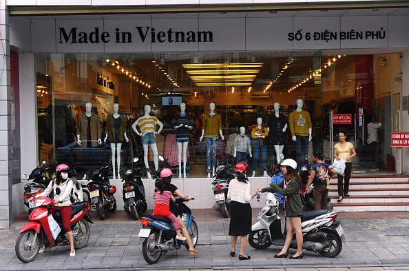 -Les femmes se préparent à quitter une boutique de vêtements vendant des produits fabriqués localement dans le centre-ville de Hanoi le 29 octobre 2014. Face à une invasion massive de biens de consommation chinois sur le marché local, les autorités ont appelé les consommateurs à acheter vietnamiens. Photo HOANG DINH NAM / AFP / Getty Images.
