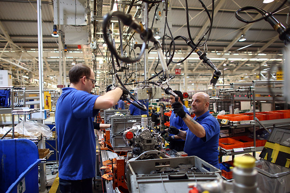 -Un employé travaille sur une ligne de production de moteurs dans une usine de Ford à Dagenham, en Angleterre. Initialement ouverte en 1931, l’usine Ford a dévoilé une chaîne de production ultramoderne. Photo de Carl Court / Getty Images.