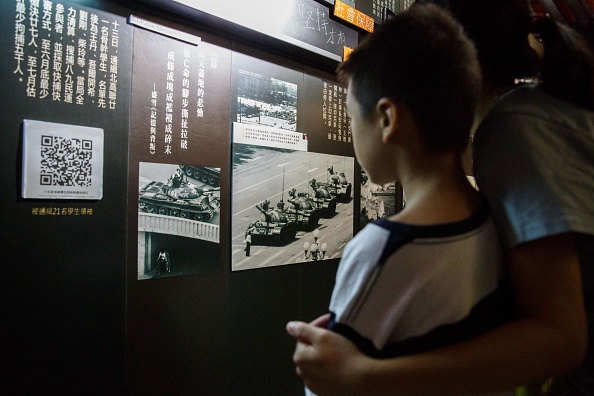 -Une mère serre dans ses bras son enfant en expliquant les photographies exposées dans le premier musée au monde consacré à la répression de la place Tiananmen de 1989 lors de la journée de clôture à Hong Kong le 11 juillet 2016, l'un des seuls lieux où l'événement peut être commémoré, des personnes tuées lors de l'écrasement brutal par les autorités de manifestants pro-démocrates à Beijing les 3 et 4 juin 1989. Photo ANTHONY WALLACE / AFP / Getty Images.