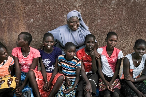 -L’école primaire de Kalas Girl, accueille des jeunes filles pour éviter les mutilations génitales féminines (MGF) et le mariage précoce, elles posent dans la ville d'Amudat, au nord-est de l'Ouganda, le 31 janvier 2018. Photo de YASUYOSHI CHIBA / AFP / Getty Images.