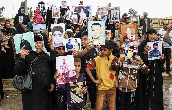 -Les Irakiens présentent des portraits de leurs proches portés disparus capturés par des combattants du groupe État islamique lors d'une manifestation à l'est de la ville de Mossoul, dans le nord du pays, le 13 avril 2018. Après des vécus difficiles à porter il est difficile de se pardonner. Photo de Waleed AL-KHALID / AFP / Getty Images.