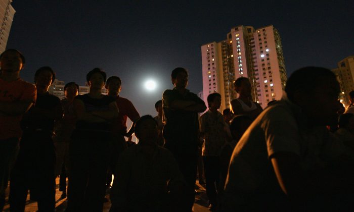 Des gens dans un quartier d'immeubles en Chine. (Guang Niu / Getty Images)