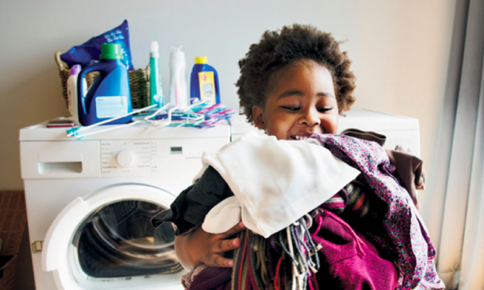 Un enfant à côté d'une machiner à laver (Rawpixel.com/Shutterstock)