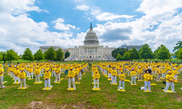 Les pratiquants de Falun Gong exécutent les exercices lors d'un rassemblement commémorant le 20e anniversaire de la persécution du Falun Gong en Chine, sur la pelouse ouest du Capitole, le 18 juillet 2019. (Mark Zhou/The Epoch Times)