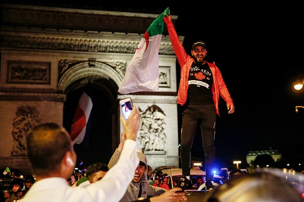 Des supporteurs de l’équipe d’Algérie fêtent la victoire de leur équipe contre le Nigéria sur les Champs-Élysées le 14 juillet 2019. Crédit : ABDULMONAM EASSA/AFP/Getty Images.