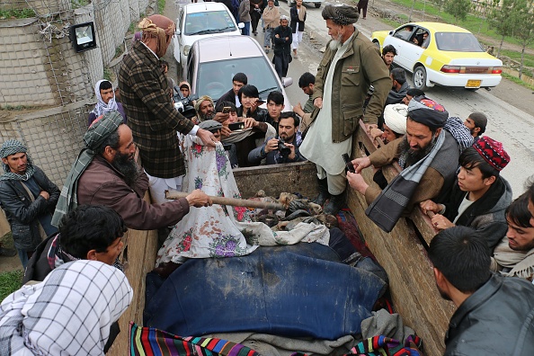 -Des hommes afghans découvrent les cadavres de jeunes enfants étendus dans un camion, après avoir été tués lors d'une frappe aérienne dans la province de Kunduz. Au moins 13 personnes ont été tués, des enfants pour la plupart, lors d'une attaque aérienne des "forces internationales" d’après les Nations Unies le 25 mars. Photo de BASHIR KHAN SAFI / AFP / Getty Images.